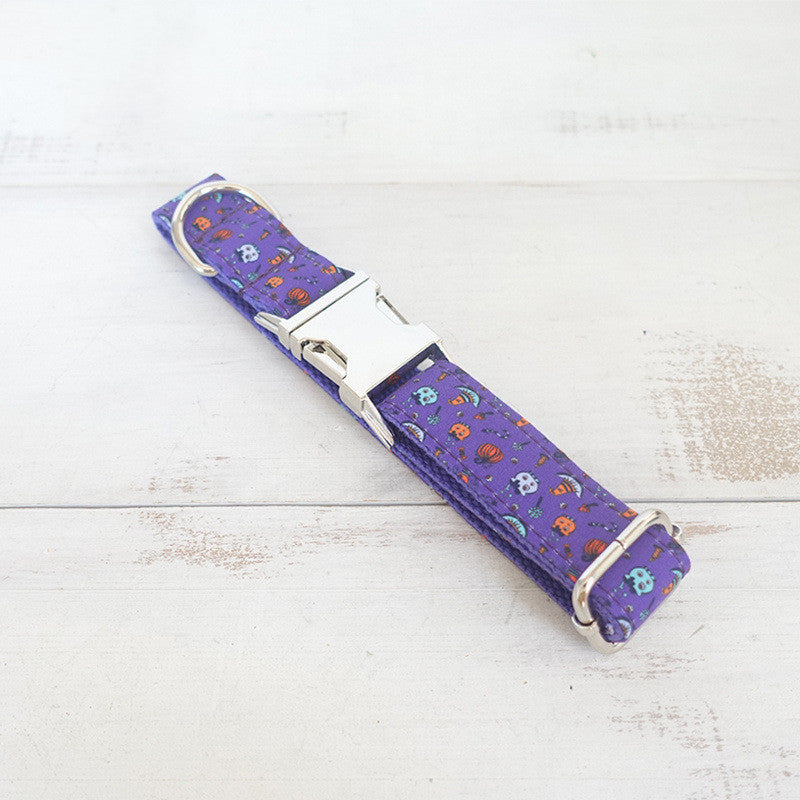 Laid flat purple Halloween dog collar featuring metal buckle and D-ring on light wood surface