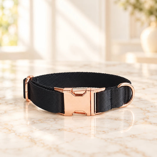 Black adjustable dog collar with rose-gold-tone buckle and D-ring on ivory marble
