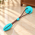 Charger l'image dans la visionneuse de la galerie, Turquoise oval dog tug toy with brown cord and matching suction cup on light ivory-beige marble
