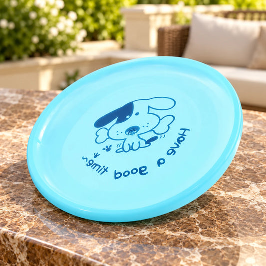 Light blue dog flying disc with the original dog-and-bone print on a brown marble terrace table.