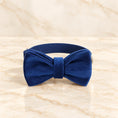 Cargar la imagen en la vista de la galería, Navy velvet bow collar with silver hardware on light ivory-beige marble.
