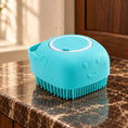 Load image into Gallery viewer, Blue square silicone pet bath brush with shampoo chamber on brown marble in a softly lit bathroom.
