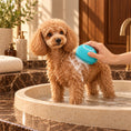 Load image into Gallery viewer, Apricot miniature poodle beside a blue silicone shampoo brush in a warm marble bathroom.
