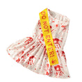 Charger l'image dans la visionneuse de la galerie, Close-up flat lay of white pet dress with red blood splatter and bright yellow Do Not Enter sash
