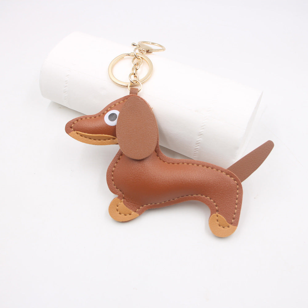 Tan faux leather sausage dog keychain with visible stitching on white background