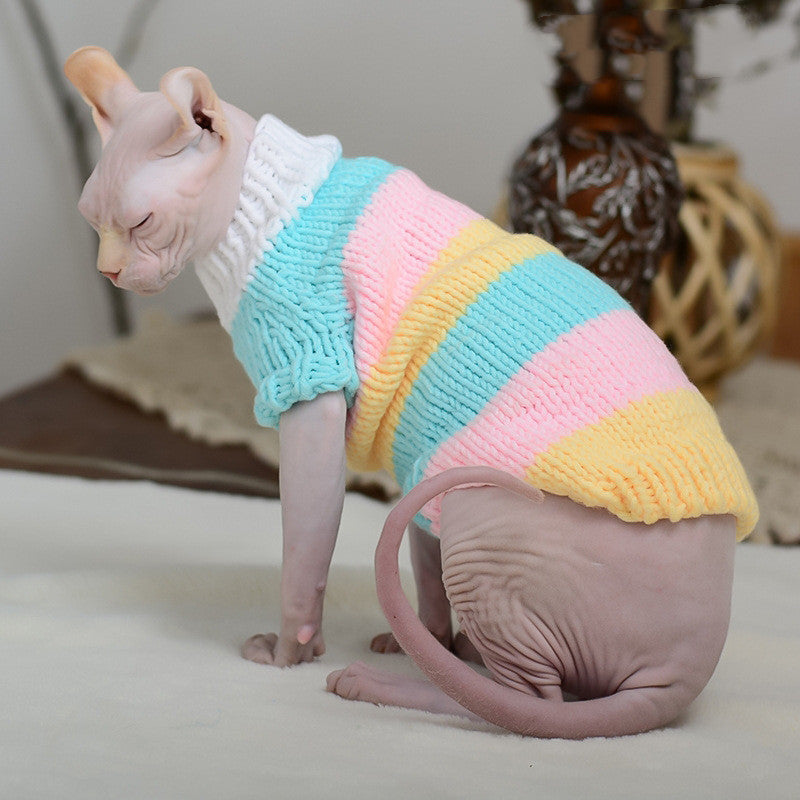 Hairless cat wearing a pastel rainbow striped wool sweater sitting with eyes closed