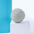 Load image into Gallery viewer, White rope-textured ball dog toy positioned on a white pedestal with blue background

