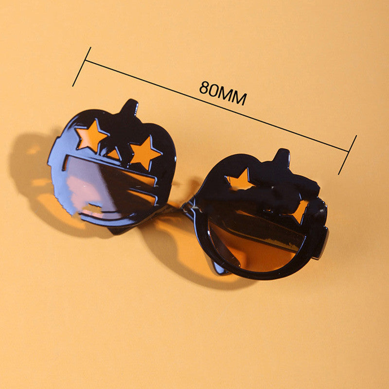 Close-up of black and orange pumpkin pet sunglasses with star-shaped eye holes next to measurement showing 80mm width