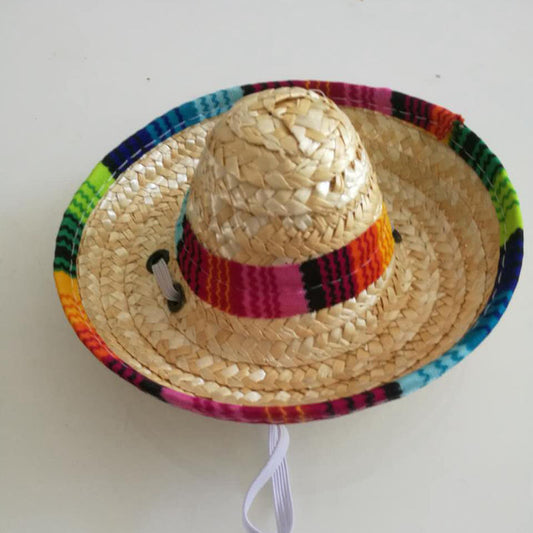 Close-up of mini pet straw hat showing colorful fabric band and strap on white background