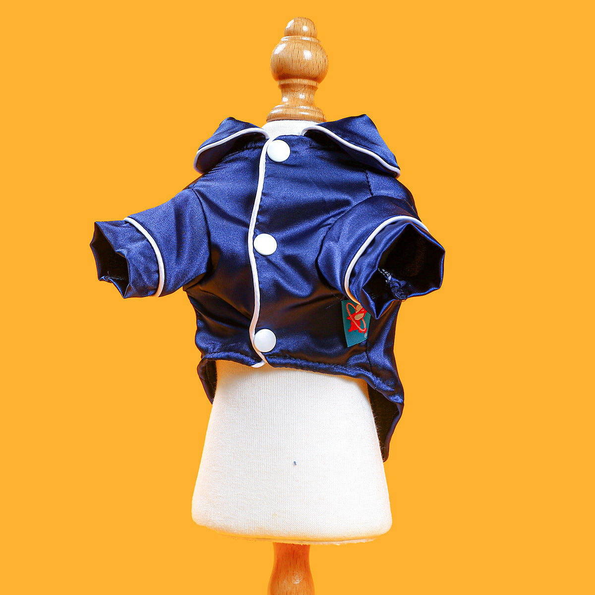 Front view of navy blue silky dog pajama shirt with button closure and white piping on mannequin