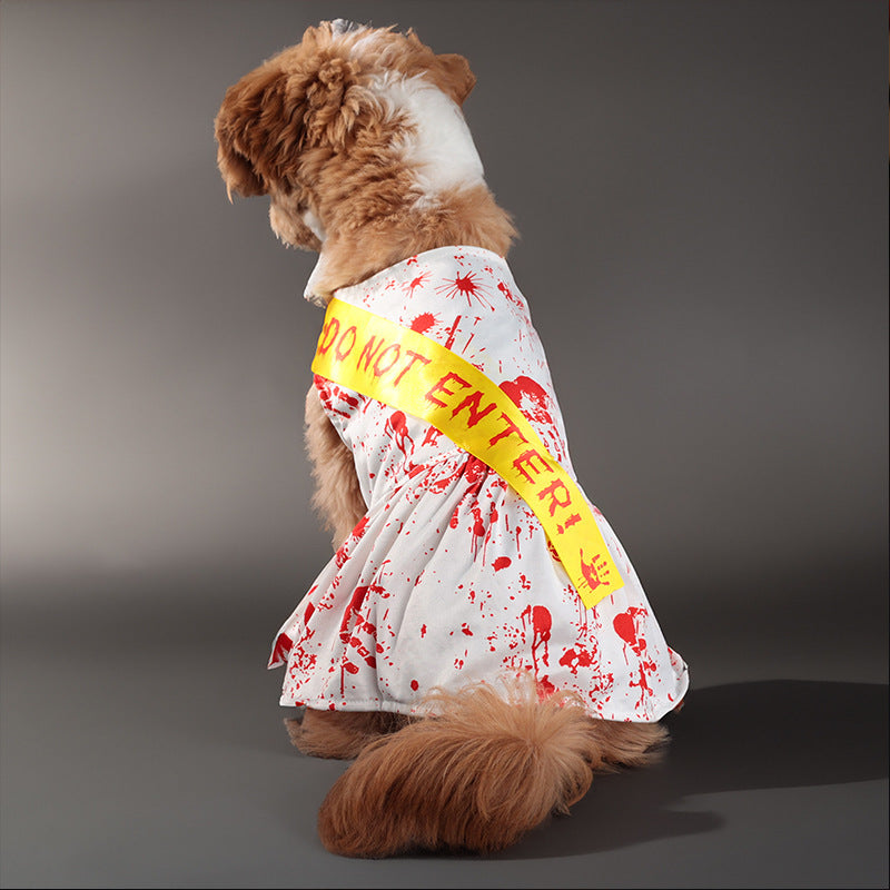 Dog sitting showing back of white dress costume with red blood splatter and yellow Do Not Enter sash