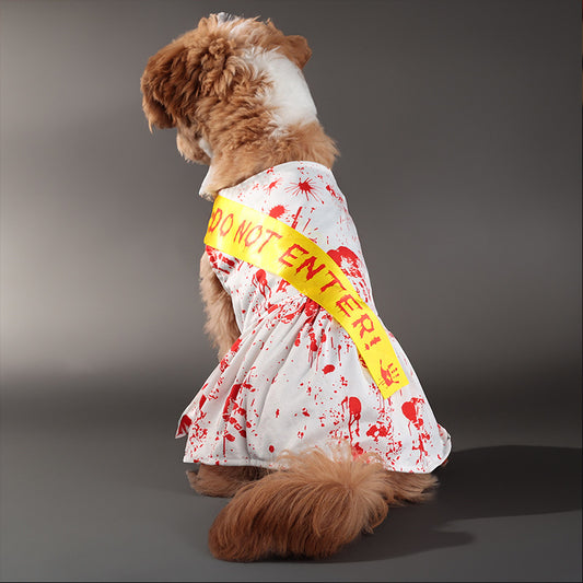 Dog sitting showing back of white dress costume with red blood splatter and yellow Do Not Enter sash