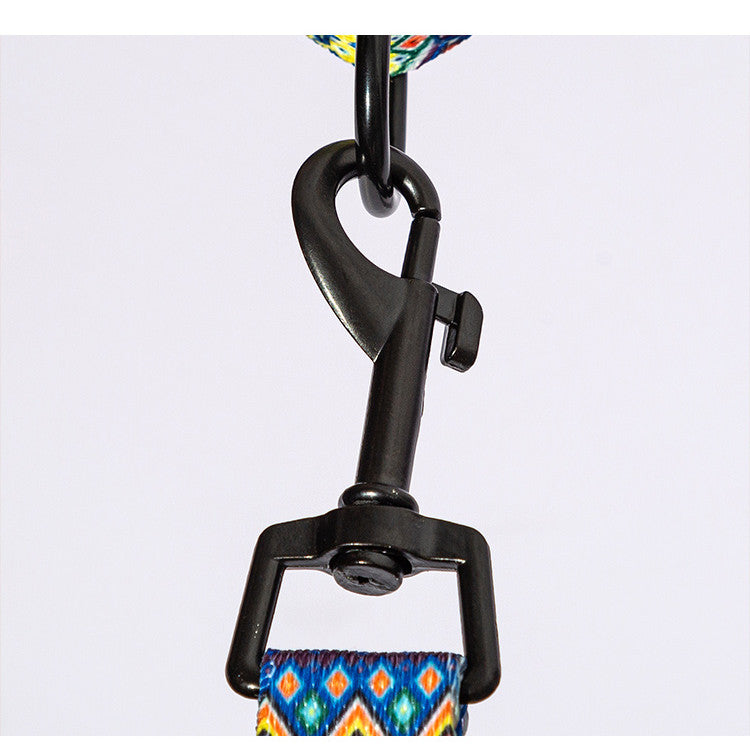 Close-up of black metal leash hook attached to blue and orange diamond patterned dog leash