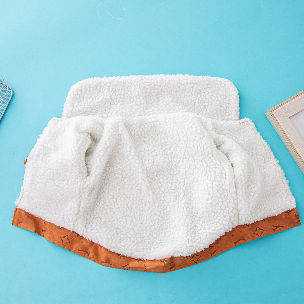 Close-up of inside fleece lining of orange-brown dog jacket laid flat on blue background