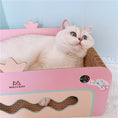 Charger l'image dans la visionneuse de la galerie, Cat lying comfortably inside pink corrugated cat scratcher bed showing side view
