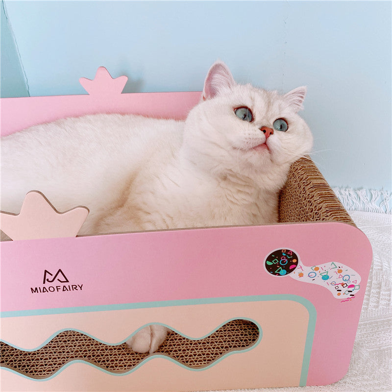 Cat lying comfortably inside pink corrugated cat scratcher bed showing side view