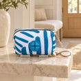 Cargar la imagen en la vista de la galería, Blue-and-white striped waste-bag pouch on a beige marble shelf in a cream entryway
