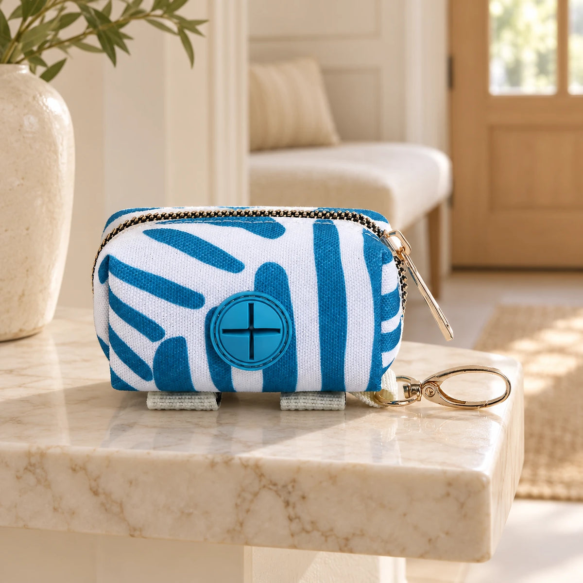 Blue-and-white striped waste-bag pouch on a beige marble shelf in a cream entryway