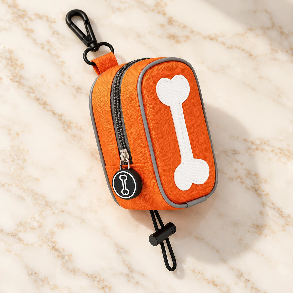 Orange bone-design waste-bag pouch with white bone motif, clip and toggle loop