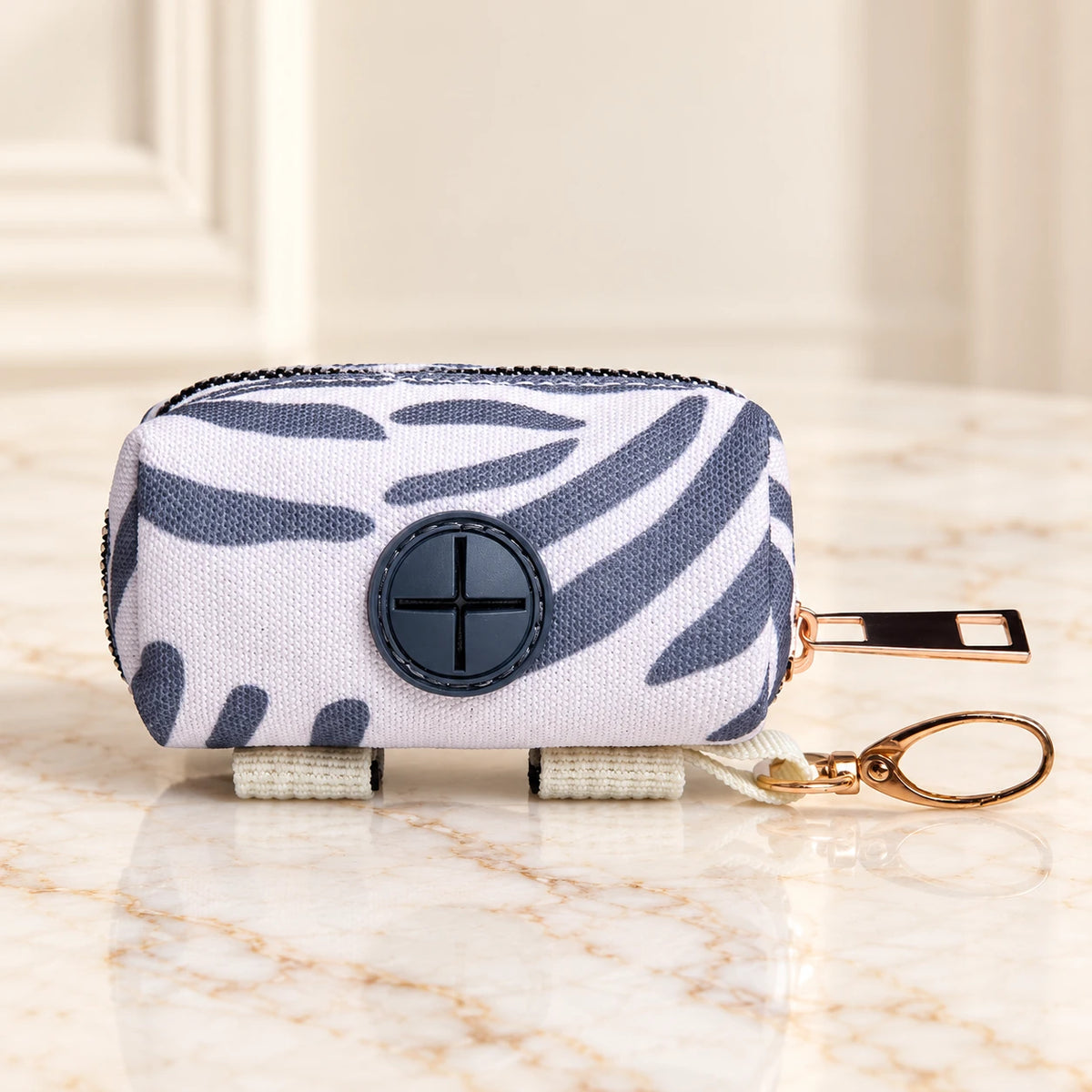 Grey-and-white striped waste-bag pouch with dark dispensing port and gold-tone clip