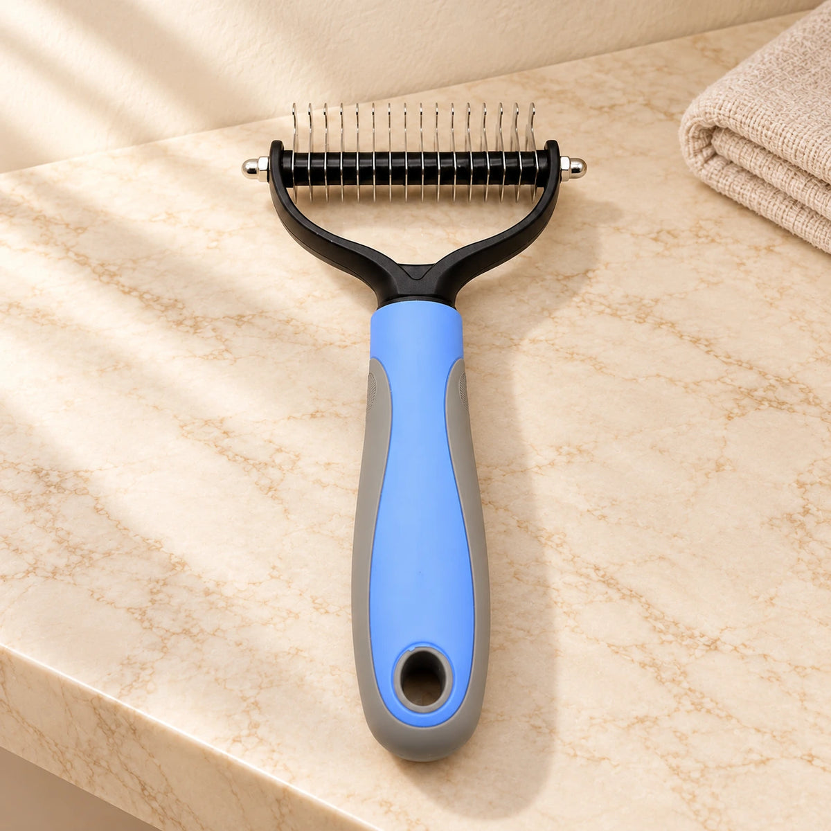 Blue and grey double-sided grooming comb, large head, on beige marble