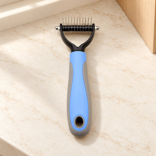 Blue and grey double-sided grooming comb, small head, on beige marble