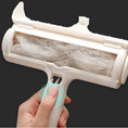 Load image into Gallery viewer, Close-up of person opening pet hair remover roller with pet hair collected inside
