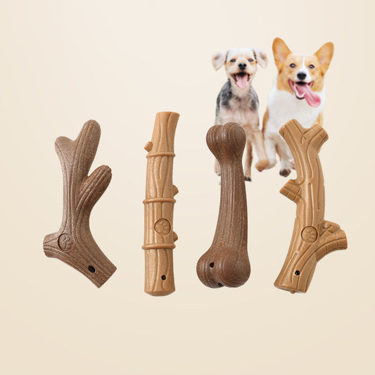 Four dog chew toys shaped like sticks and bones with two small happy dogs in background