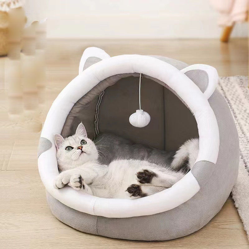Gray and white plush cat cave bed with white mesh ears and hanging pompom, cat playing inside