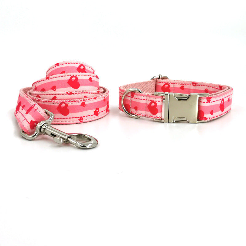 Pink dog collar and matching leash with red heart patterns on a white background