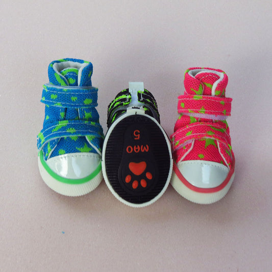 Front view of three dog sneakers showing rubber soles with paw print design and adjustable straps.