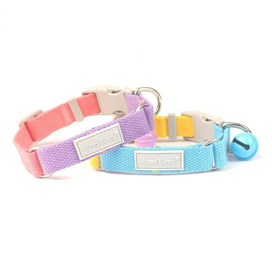 Four colorful dog collars with matching bells in pink-purple, blue-yellow, yellow-purple, and orange-green combinations