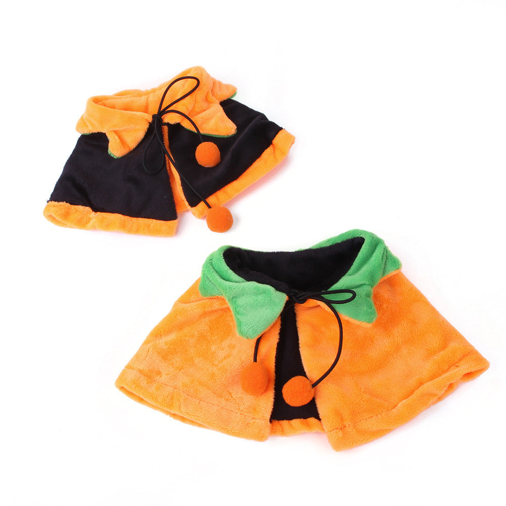 Two reversible pumpkin cloaks laid flat showing double-sided designs: one side orange with green leaf collar, the other black with orange trim and green collar, both with black tie strings and orange pom-poms.