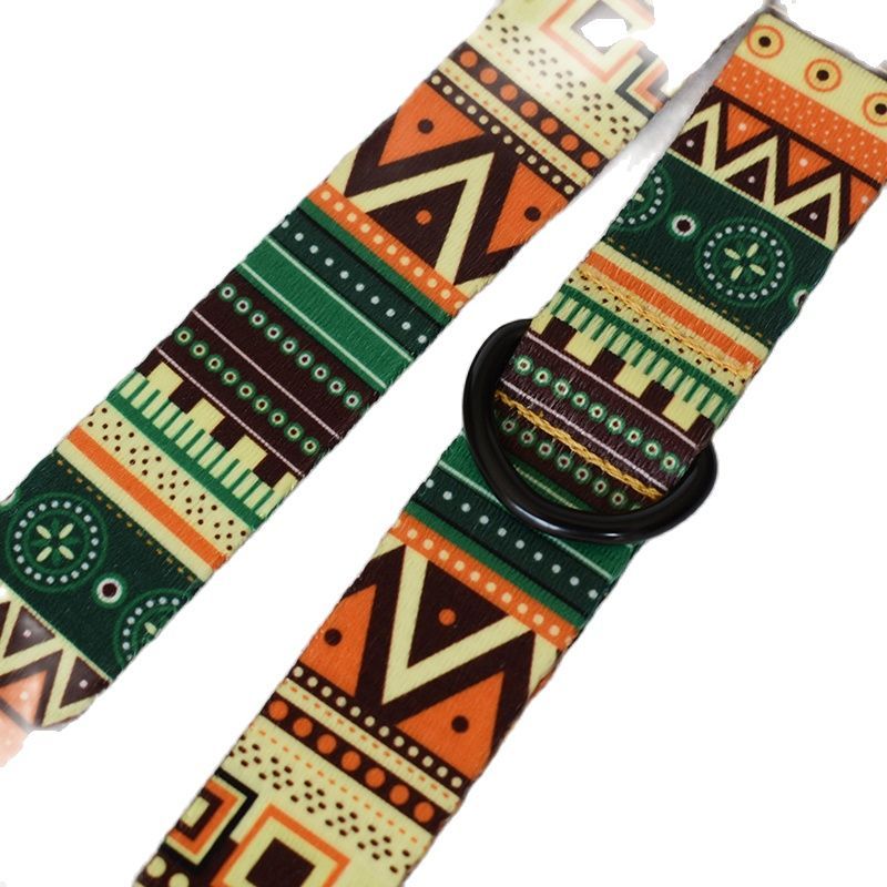 Close-up of green, orange, and black geometric patterned nylon dog collar fabric showing plastic buckle and metal D-ring