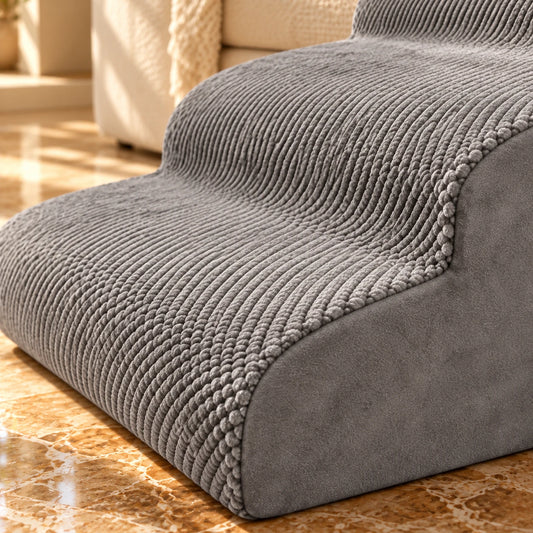 Close-up of the grey textured fabric and rounded tread edges on three-step foam pet stairs.