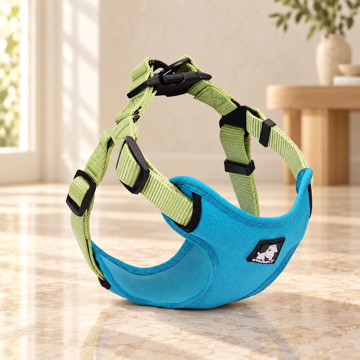 Blue green adjustable dog harness with chest panel and webbing straps on beige marble