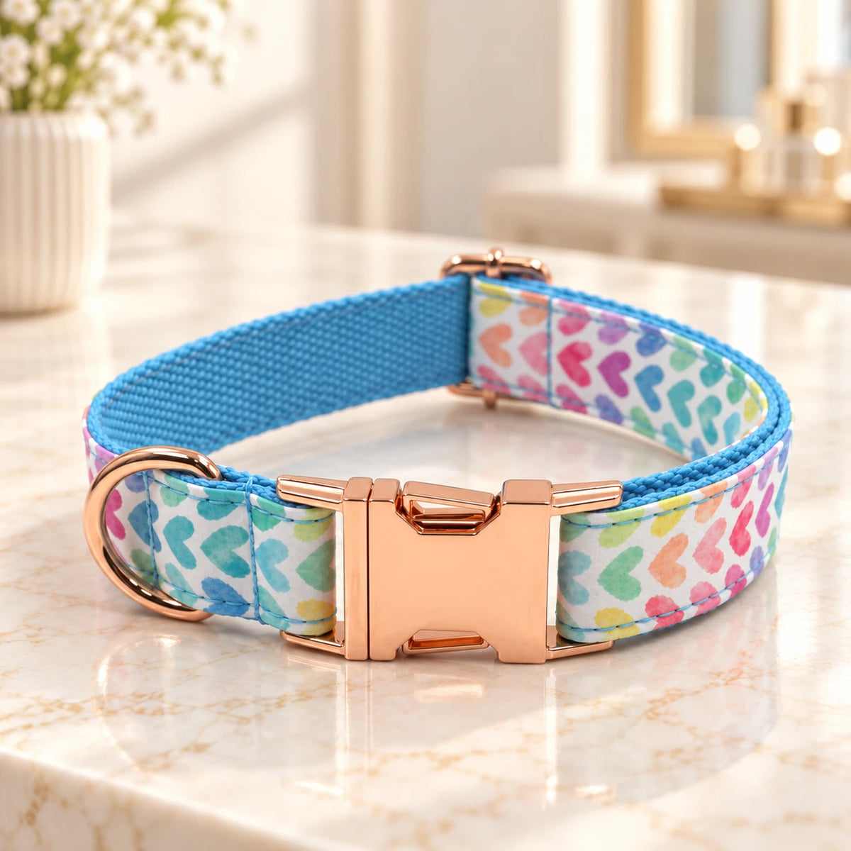 Heart-print dog collar with turquoise inner webbing and rose-gold buckle on ivory marble