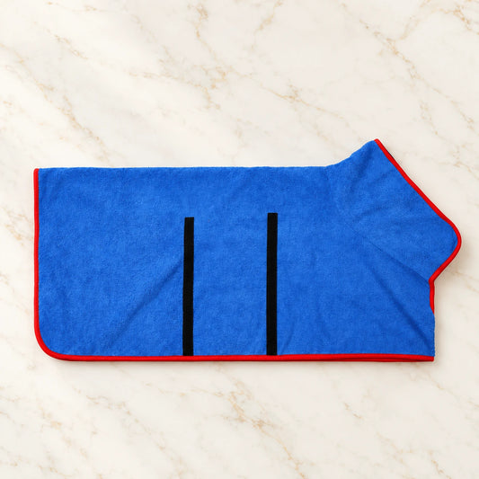 Blue dog drying robe with red edging and black fastening strips on ivory marble