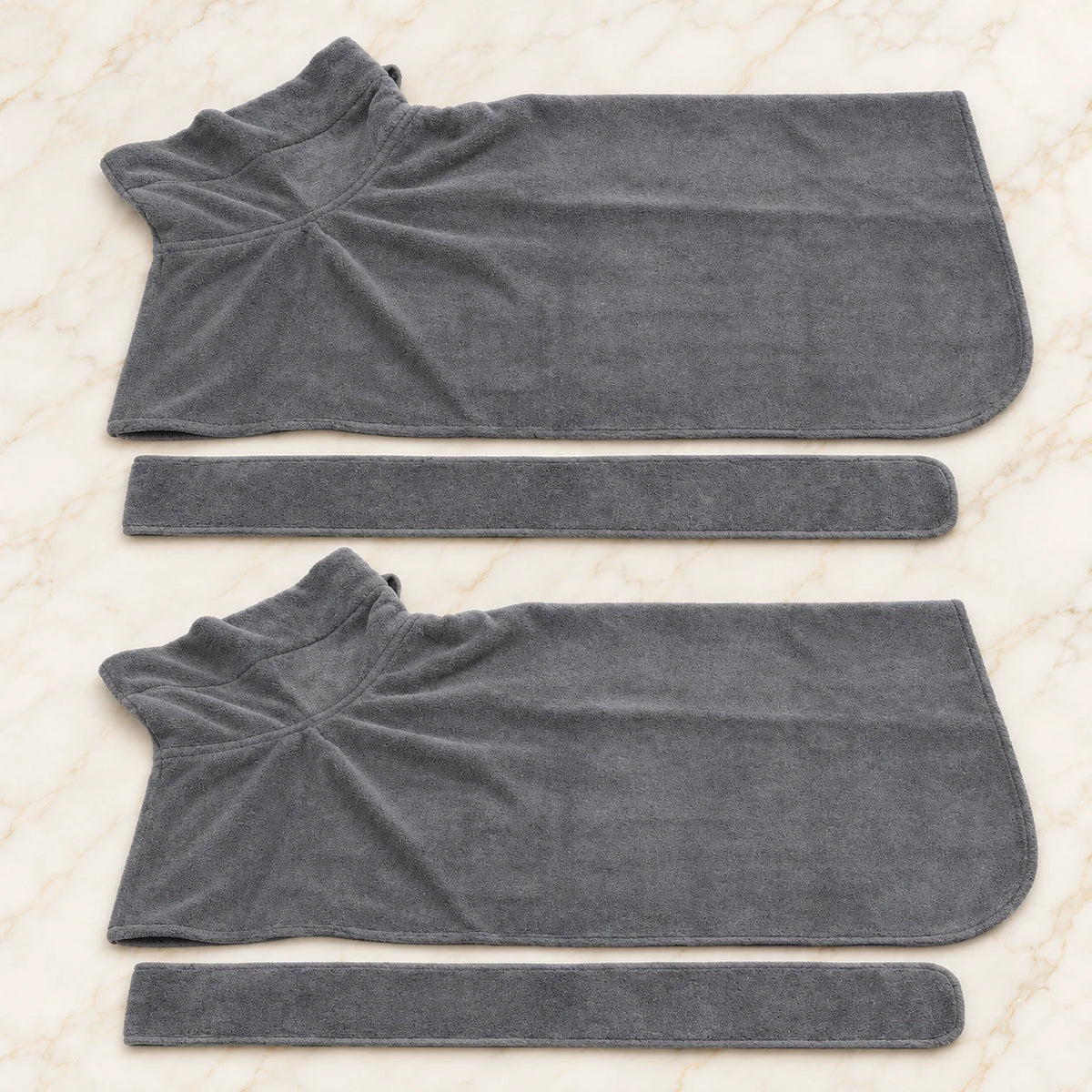 Two plain grey dog drying robes with two matching belts on ivory marble