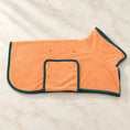 Load image into Gallery viewer, Peach orange dog drying robe with dark teal edging and snap fasteners on ivory marble
