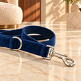 Cargar la imagen en la vista de la galería, Close-up of navy velvet leash stitching, woven backing, silver D-ring and snap clasp on light ivory-beige marble.
