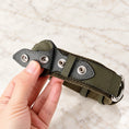 Load image into Gallery viewer, Hand opening the double-snap tracker holder on an olive dog collar

