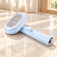 Load image into Gallery viewer, Pale blue steel-pin pet grooming brush with oval head on an ivory marble surface
