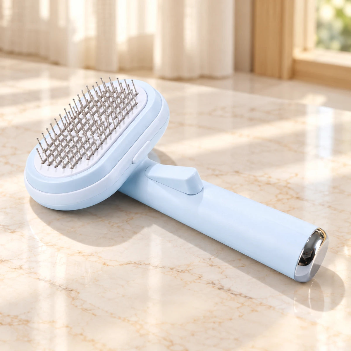 Pale blue steel-pin pet grooming brush with oval head on an ivory marble surface