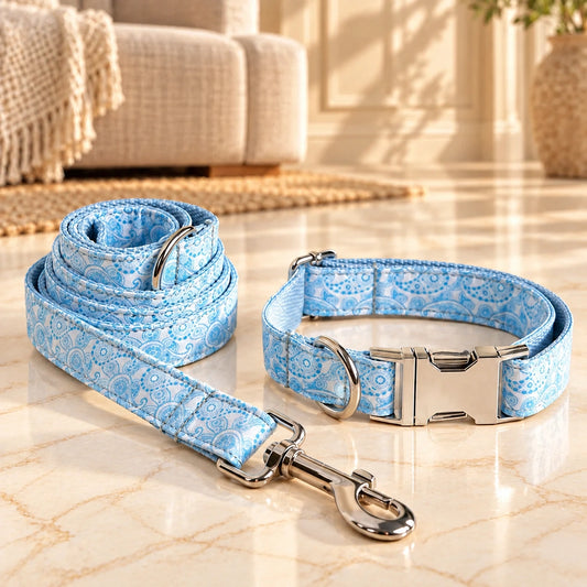 Light blue paisley dog collar and matching leash with silver hardware on honey-light ivory-beige marble.