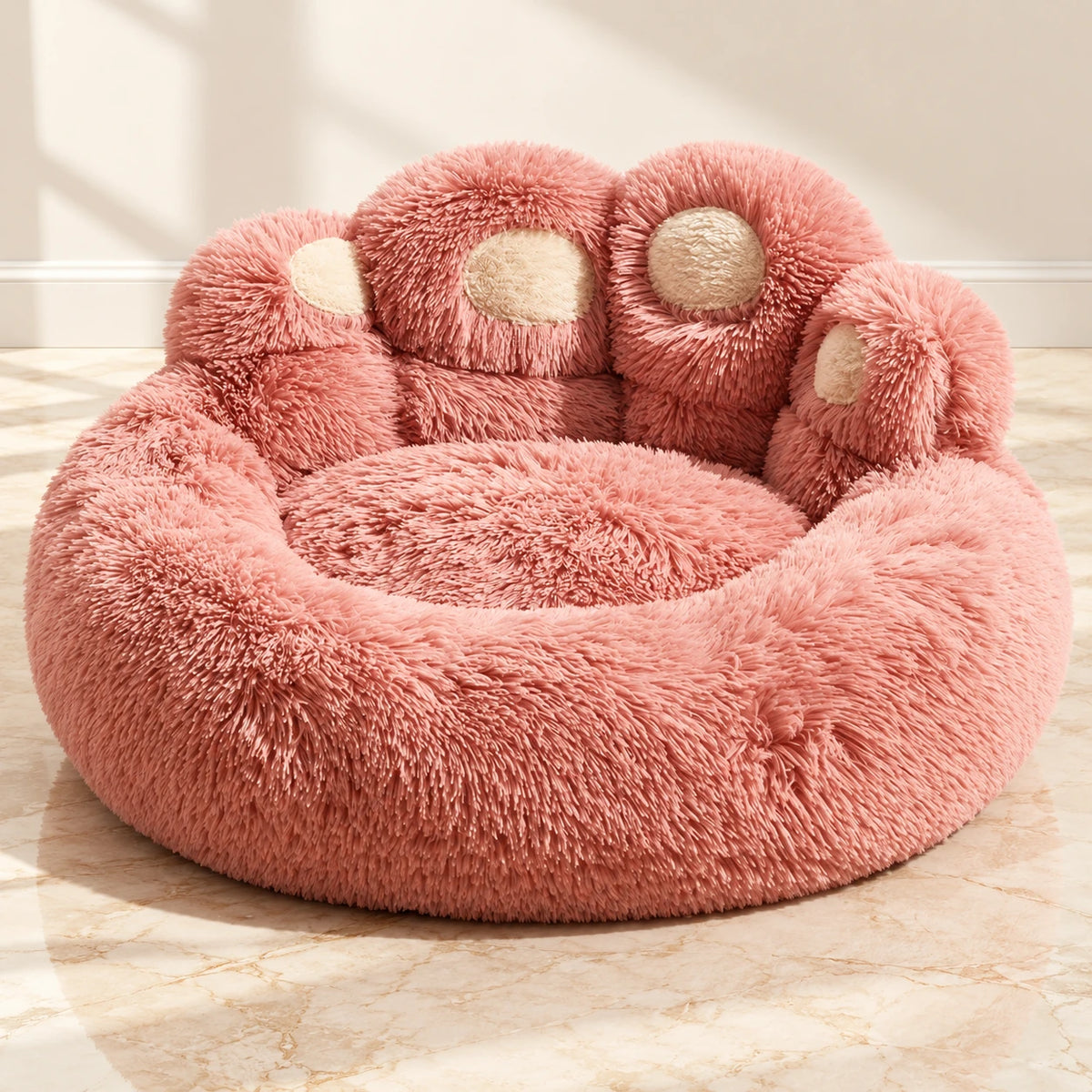 Pink plush paw-shaped pet bed with cream toe pads on ivory marble
