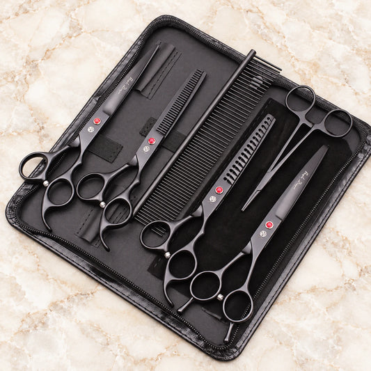 Black pet grooming set with four scissors, comb and forceps in an open black zip case
