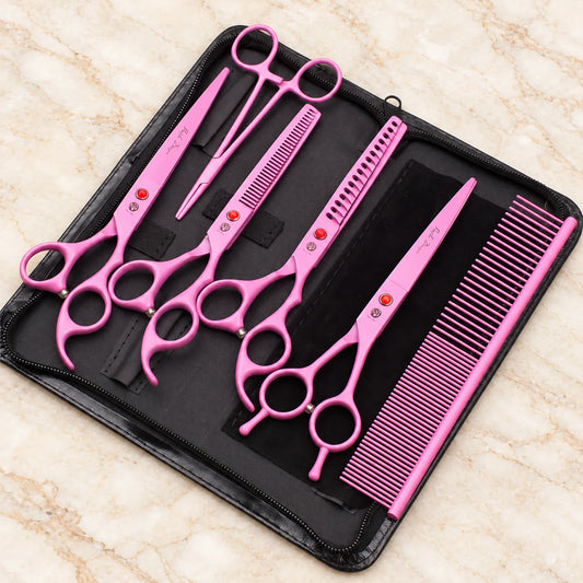 Pink pet grooming set with four scissors, comb and forceps in an open black zip case