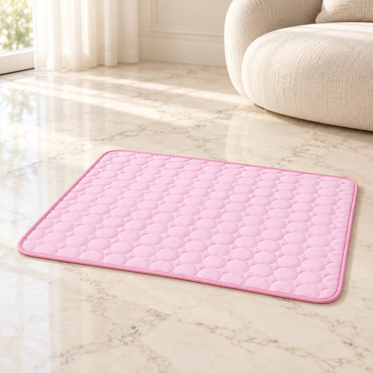 Pink quilted cooling pet mat with rounded corners on cream marble