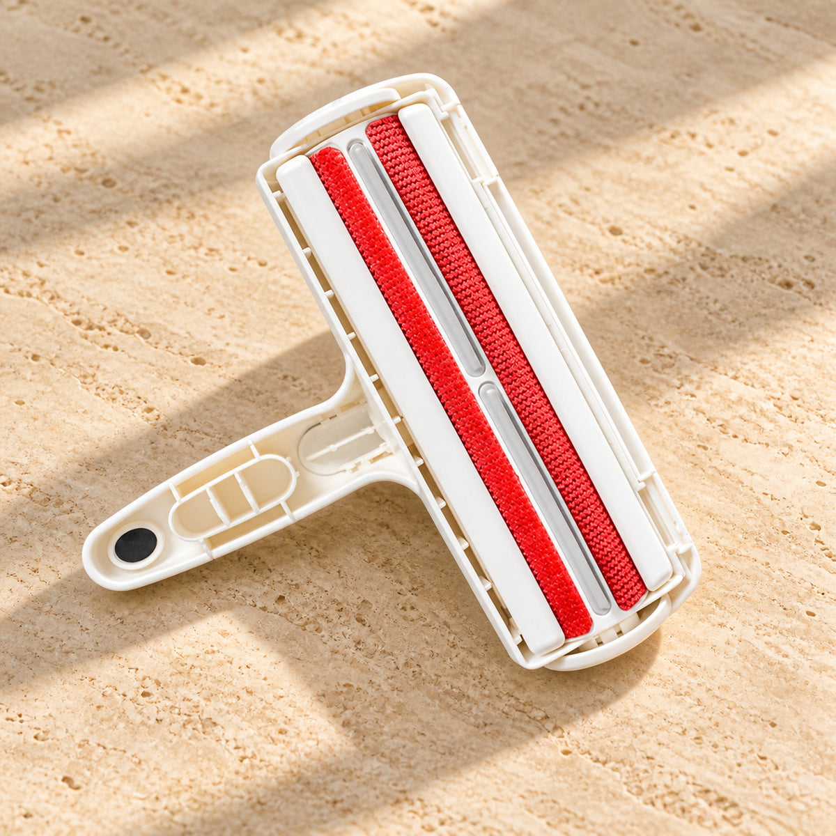 Red lint-stripping surfaces on the underside of the white pet hair remover